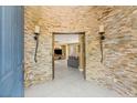 Stunning entryway showcasing stone accent walls, sconces and a view into the open living space at 11764 Golden Moments Ave, Las Vegas, NV 89138
