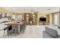 Spacious living room with a stone accent wall, large island with seating, and modern decor at 11764 Golden Moments Ave, Las Vegas, NV 89138