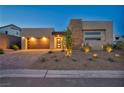 Modern single-Gathering house with a three car garage, attractive landscaping, and modern architectural design at 11954 Camden Ridge Ct, Las Vegas, NV 89138
