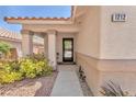 Inviting front porch with desert landscaping, neutral color palette, and decorative columns at the entrance at 1212 Anime Dr, Las Vegas, NV 89144