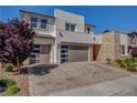 Beautiful home featuring a stone facade, desert landscaping, and a three-car garage at 2579 Speyburn Ave, Henderson, NV 89044