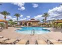 Resort-style pool area with sun loungers, cabanas, palm trees, and a clubhouse for relaxing and entertaining guests at 2717 Mona Lisa St, Henderson, NV 89044