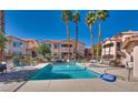 Full community pool view with lounge chairs and desert landscaping; enjoy the outdoor amenities of this complex at 350 S Durango Dr # 220, Las Vegas, NV 89145
