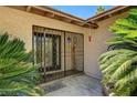 Inviting front entrance with secure iron gate, palm trees, and a decorative hummingbird feeder at 3753 S Rosecrest Cir, Las Vegas, NV 89121