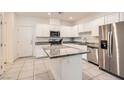 Bright kitchen featuring white cabinets, granite countertops, stainless steel appliances and a large island at 489 Filaree Pl, Henderson, NV 89015