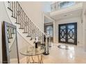 Elegant foyer with decorative staircase, marble floors, and a view of the front door at 5367 Secluded Brook Ct, Las Vegas, NV 89149