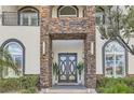 Close up of the stone entryway with double doors and manicured landscaping at 5367 Secluded Brook Ct, Las Vegas, NV 89149
