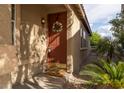 Cozy front porch featuring a decorative wreath, garden and 'happy hour' welcome mat at 6623 Brick House Ave, Las Vegas, NV 89122