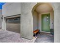 Home's stylish covered entryway features a unique arched alcove and modern front door at 6830 Compass St, North Las Vegas, NV 89084