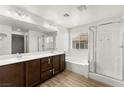 Bright bathroom with double sinks, soaking tub, and glass-enclosed shower at 7189 Ashcroft St, North Las Vegas, NV 89084