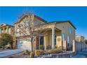 Two-story home with brick accents, a cozy front porch, and a landscaped yard at 7337 Savannah Falls St, Las Vegas, NV 89131