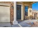 Inviting front porch with seating area, wreath, and well-manicured landscaping at 7337 Savannah Falls St, Las Vegas, NV 89131