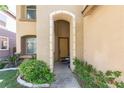 Inviting entryway framed by stone archway and green foliage with flowers at 7736 Villa Andrade Ave, Las Vegas, NV 89131