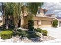 Two-story home with manicured landscaping, green lawn, and inviting curb appeal at 7736 Villa Andrade Ave, Las Vegas, NV 89131