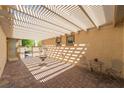 Relaxing covered patio with brick flooring, fountain, and elegant outdoor furniture at 8236 Imperial Lakes St, Las Vegas, NV 89131