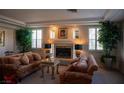 Cozy living room features a fireplace, plush sofas, and large potted plants for a comfortable and inviting atmosphere at 9905 Fox Springs Dr, Las Vegas, NV 89117