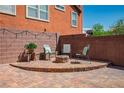 Brick patio featuring an outdoor seating area and a charming stone fire pit at 10030 Trotter Peak St, Las Vegas, NV 89178