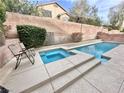 Backyard pool featuring a spa, lounging chairs, and privacy wall at 10680 Sapphire Vista Ave, Las Vegas, NV 89144
