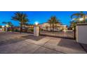 Elegant home featuring a gated entrance, lush landscaping, and a long driveway at 2780 El Camino Rd, Las Vegas, NV 89146