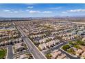 Expansive aerial view of a residential community with houses, streets, and distant mountains under a blue sky at 2929 Salado Creek Ave, North Las Vegas, NV 89081