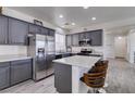 Modern kitchen with stainless steel appliances, sleek gray cabinetry, quartz countertops and a functional center island with seating at 2929 Salado Creek Ave, North Las Vegas, NV 89081