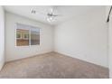 Bright bedroom with neutral carpet, ceiling fan, and window with blinds, offering a simple and comfortable living space at 4217 Box Canyon Falls Ave, North Las Vegas, NV 89085