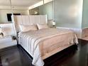 A beautifully designed bedroom with a soft color palette, dark hardwood floors and mirrored accents at 4381 W Flamingo Rd # 1504, Las Vegas, NV 89103