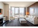 Modern living room with comfortable seating, a large window with city views, and sleek furnishings at 4381 W Flamingo Rd # 1504, Las Vegas, NV 89103