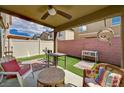 Relaxing covered patio with seating area, artificial grass, and privacy fence at 6231 Portland Treaty Ave, Las Vegas, NV 89122