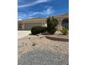 Inviting home showcasing a attached garage, desert landscape and arched entryway, seamlessly blending curb appeal and functionality at 6841 Longmeadow Dr, Pahrump, NV 89061