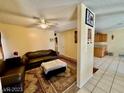 Cozy living room with plush seating, tile flooring, and an open view to the kitchen at 6955 Grassy Knoll St, Las Vegas, NV 89147