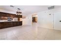 Open-concept kitchen and living area with dark wood cabinetry and tile flooring at 711 Sari Dr, Las Vegas, NV 89110