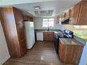 Updated kitchen featuring brown cabinets, granite countertops, and black appliances at 7200 Pirates Cove Rd # 2025, Las Vegas, NV 89145