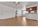 Open-concept living room features wood-look floors and transitions to a breakfast bar and kitchen at 7200 Pirates Cove Rd # 2025, Las Vegas, NV 89145