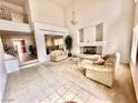 Bright living room with high ceilings, fireplace, chandelier, and staircase leading to the second floor at 7851 Tidal Pool Ct, Las Vegas, NV 89139