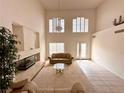 Bright, high-ceiling living room with fireplace, chandelier, and large windows at 7851 Tidal Pool Ct, Las Vegas, NV 89139