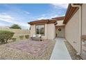 Inviting front porch with tiled patio, a cozy bench, and meticulously xeriscaped yard at 7908 House Sparrow St, North Las Vegas, NV 89084