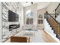 Elegant living room with fireplace, high ceilings, large windows, and modern staircase at 8113 Bay Springs Dr, Las Vegas, NV 89128