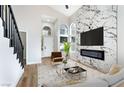 Bright living room with fireplace, large windows, and modern staircase at 8113 Bay Springs Dr, Las Vegas, NV 89128
