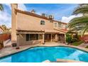Relaxing pool area with outdoor seating, lush landscaping, and covered patio provides the perfect space for unwinding at 905 Possum Hill St, Henderson, NV 89014