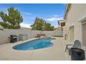 A serene backyard showcases a sparkling pool, a soothing spa, and a well-equipped grilling space at 9815 Ramhorn Canyon St, Las Vegas, NV 89183