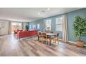 Open-concept living and dining area with sleek wood floors and plenty of natural light from large windows at 1019 Gentle Swan St # 693, Henderson, NV 89011