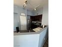 Cozy kitchen featuring stainless steel appliances, dark wood cabinets, and a breakfast bar at 10245 S Maryland Pkwy # 2216, Las Vegas, NV 89183