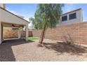 Private backyard with desert landscaping, brick wall, covered patio and a small artificial turf area at 1105 Strada Pecei, Henderson, NV 89011