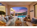 Cozy covered patio with comfortable seating overlooking the sparkling pool and serene landscape at 12217 Tempestad Ave, Las Vegas, NV 89138