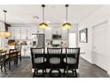 Stylish kitchen features white cabinets, stainless steel appliances, pendant lighting, and modern island seating at 12648 Heritage Bend Dr, Las Vegas, NV 89138