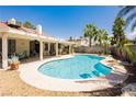 Backyard view of sparkling pool with lush landscaping and covered patio at 1528 Tonada Way, Las Vegas, NV 89117