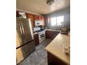 Efficient kitchen with stainless steel refrigerator, white appliances, and tiled floors, perfect for cooking at 1676 Divinity St, Las Vegas, NV 89142