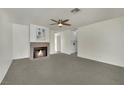 Inviting living room with neutral carpet, cozy fireplace, and a classic ceiling fan at 1676 Divinity St, Las Vegas, NV 89142