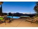 Inviting pool and spa with lounge chairs and mountain views at twilight at 19 Contrada Fiore Dr, Henderson, NV 89011